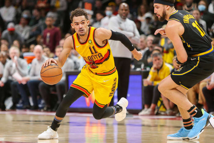 Hawks guard Trae Young dribbles past Warriors guard Klay Thompson.